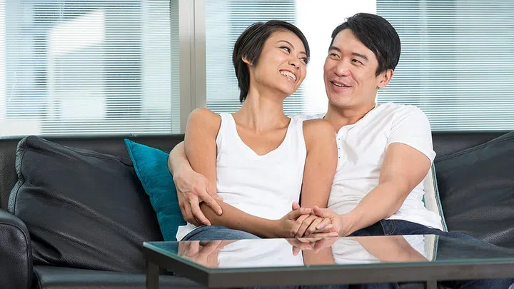 Yound and happy Chinese couple hanging out together at home