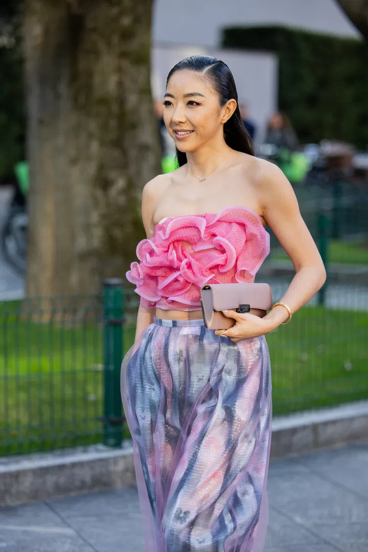 MILAN, ITALY - FEBRUARY 27: Yuwei Zhangzou wears ruffled off shoulder top in pink, skirt with print outside Emporio Armani during the Milan Fashion Week Womenswear Fall/Winter 2025/2026 on February 27, 2025 in Milan, Italy. (Photo by Christian Vierig/Getty Images)