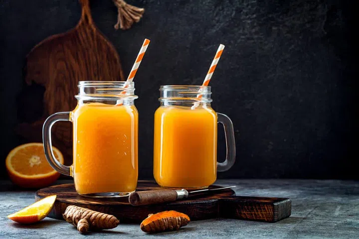 Immune boosting, anti inflammatory smoothie with orange, pineapple, turmeric. Detox morning juice drink, clean eating