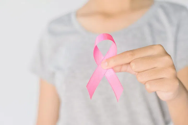 womaen hand holding pink ribbon breast cancer awareness. concept healthcare and medicine