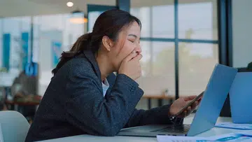 woman working and yawning