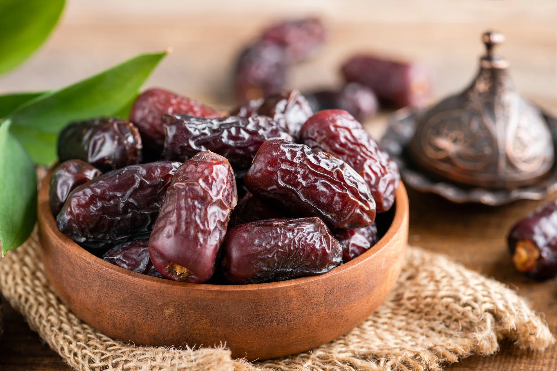 Dried medjool dates in wooden bowl. Islamic culture, Ramadan holiday concept