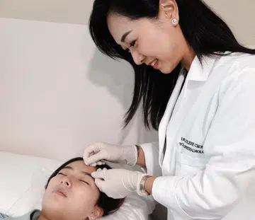 Dr Jolene Chong of Gen Eye TCM clinic administering eye acupuncture on a patient