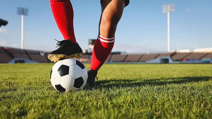 soccer or football player standing with ball on the field for Kick the soccer ball at football stadium