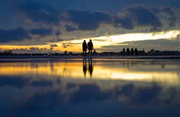 18 February 2022, Berlin: A couple walks across Tempelhofer Feld at sunset. Photo: Hauke Schröder/dpa-Zentralbild/ZB (Photo by Hauke Schröder/picture alliance via Getty Images)