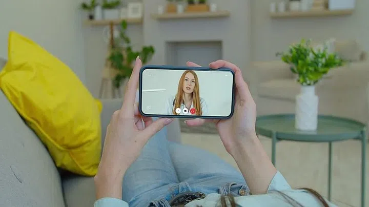 Girl using online chat to talk with professional therapist and checks possible symptoms during. Woman using medical app on smartphone consulting with doctor via video conference