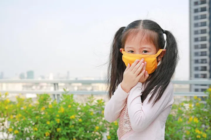 little child girl wearing a protection mask against PM 2.5 air pollution in Bangkok city. Thailand.