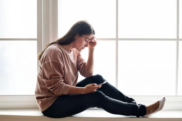 Serious and distressed woman using a smartphone
