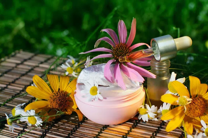 8041747 - essential oil  and box of natural cream with flowers  - beauty treatment
