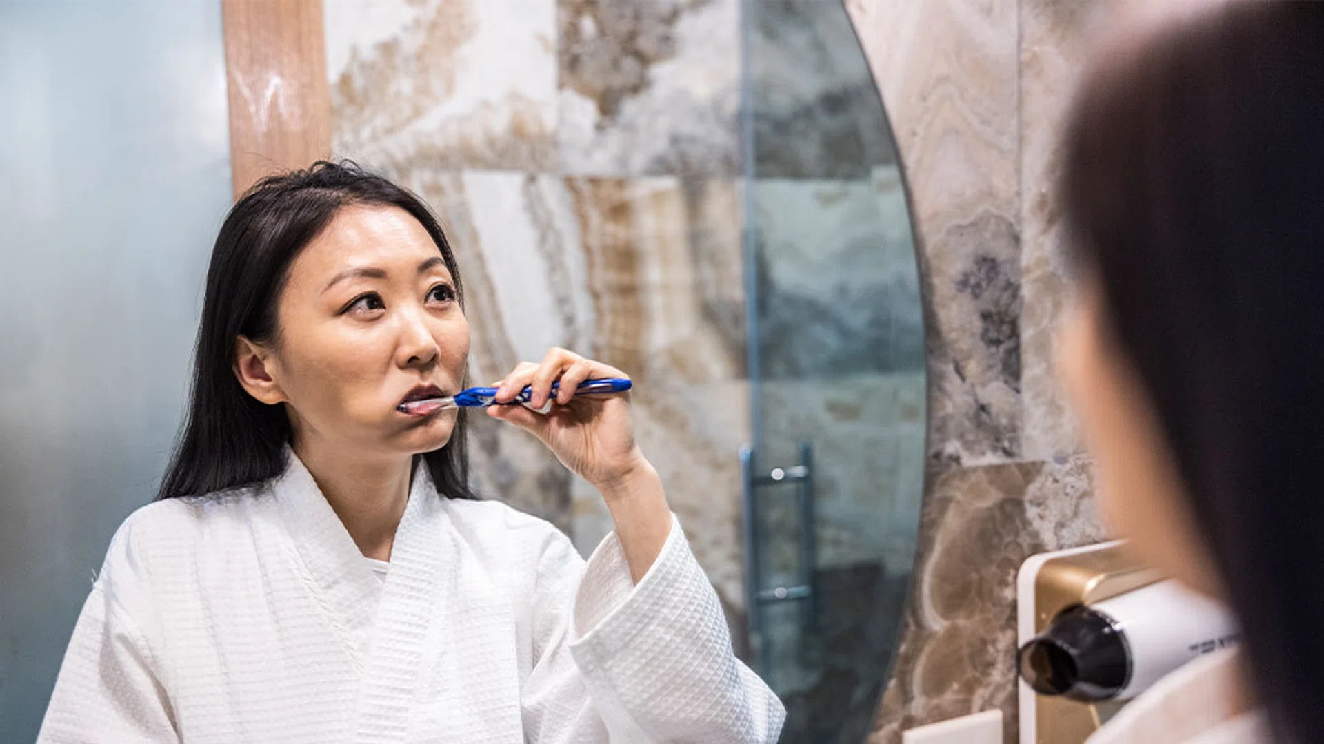 asian woman brushing teeth