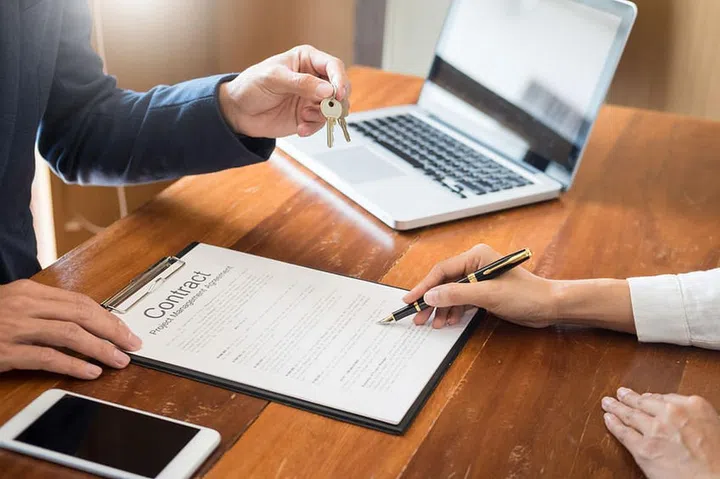 agent getting keys to customer new house, hand of real estate agent or realtor giving apartment key to receiving man after finish purchase deal agreement and sign contract, renting or buying home concept
