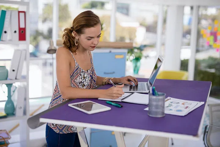 Female executive working on laptop at desk in the office