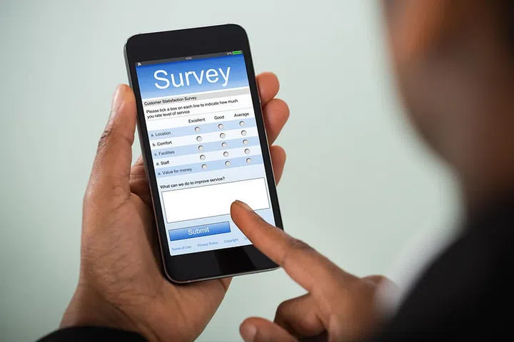 Close-up Of African Businesswoman Filling Online Survey On Mobile Phone