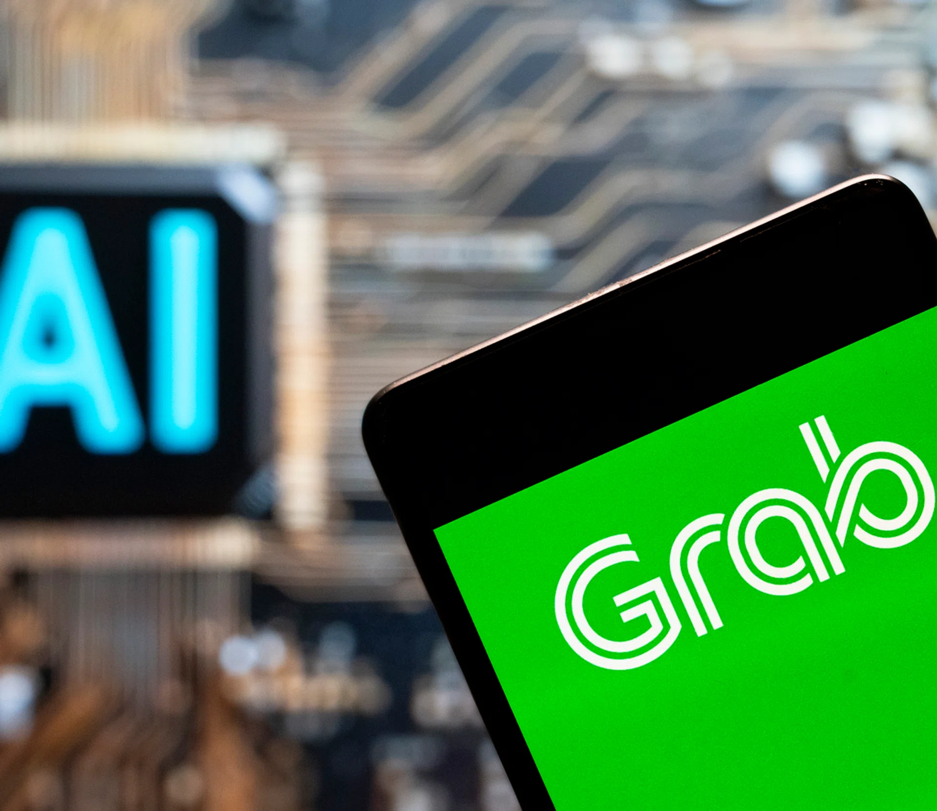CHINA - 2023/11/03: In this photo illustration, the Singapore technology ride-sharing and food delivery service company Grab Taxi logo seen displayed on a smartphone with an Artificial intelligence (AI) chip and symbol in the background. (Photo Illustration by Budrul Chukrut/SOPA Images/LightRocket via Getty Images)