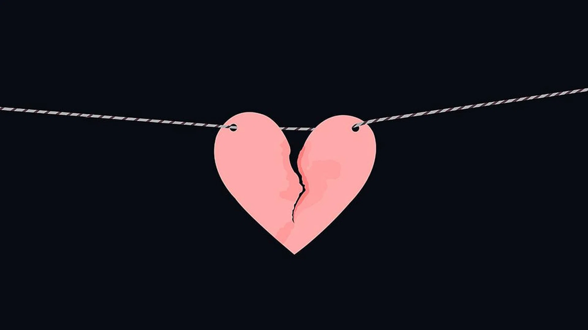 Pink heart shaped paper with torn marks hanging on the rope. Broken heart,unrequited love.