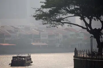 SINGAPORE - JUNE 19:  Smoke haze covers shop along Boat Quay on June 19, 2013 in Singapore. The haze is created by deliberate slash-and-burn forest fires started by companies in neighbouring Sumatra.The Pollutant Standards Index (PSI) rose to 172 at 3pm, the worst since 1997.  (Photo by Chris McGrath/Getty Images)