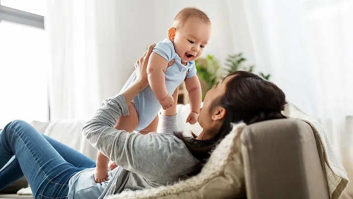 family and motherhood concept - happy young asian mother with little baby son at home