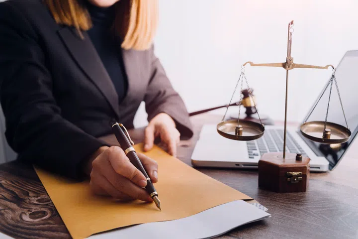 Business and lawyers discussing contract papers with brass scale on desk in office. Law, legal services, advice, justice and law concept picture with film grain effect