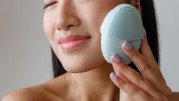 Woman using a skincare device for glowing, youthful skin at home