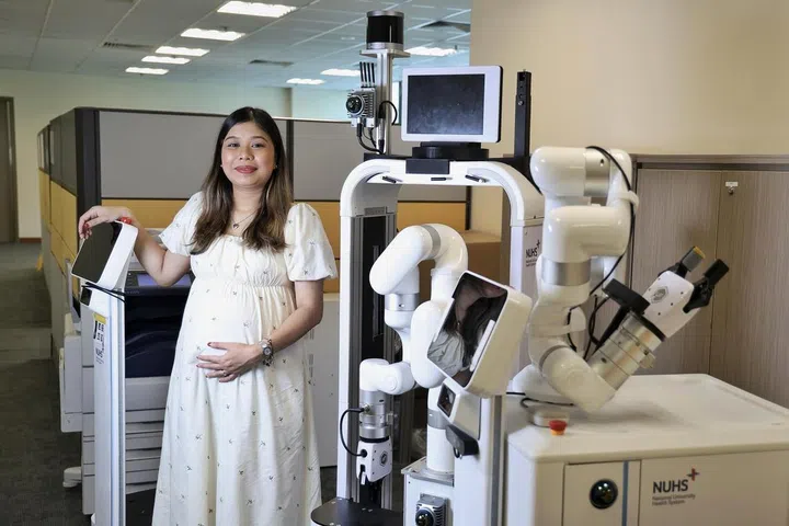 Ms Wan NurSabrina Wan Nasarudin with a robot nurse companion that she uses in her work on digital twin simulations of the National University Hospital to test scenarios involving robots.