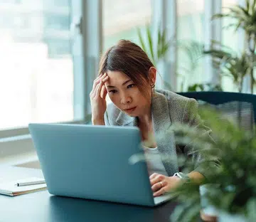Tired Asian businesswoman working on a laptop computer in the office | Year of the fire horse, 2026 career forecast