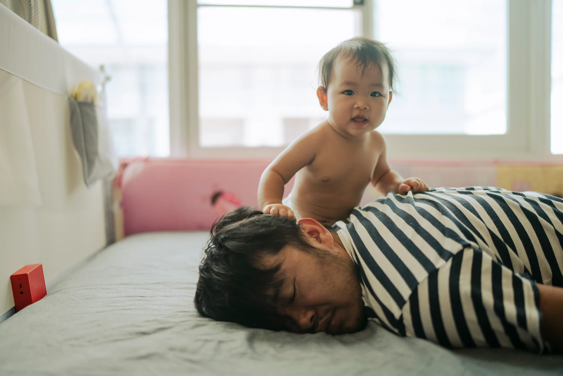 Morning Mood Asian baby wake up early before daddy and playful on the bed