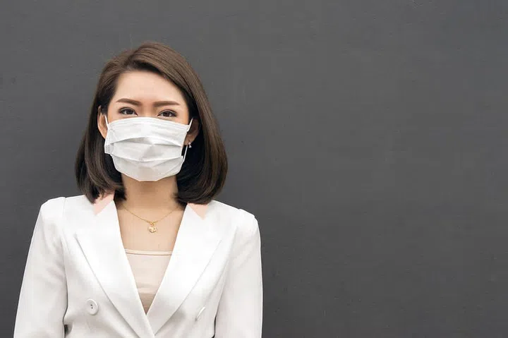 Woman suffer from sick and wearing face mask., asian woman in protective mask feeling bad on the street in the city with air pollution.