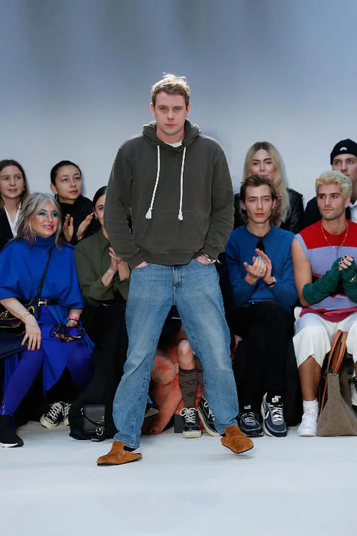 British designer Jonathan Anderson taking a bow in an ultimate no-frills outfit – complete with a pair of mules – at his Fall/Winter 2020 show in London.