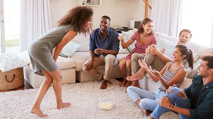 Group Of Friends At Home Having Fun Playing Charades Together