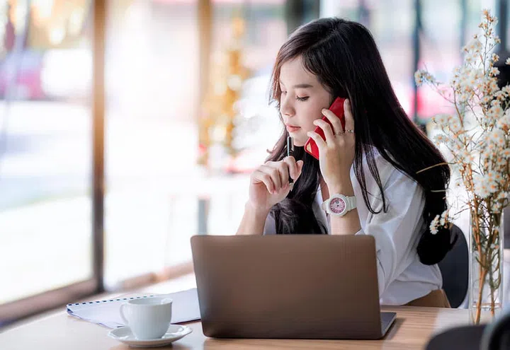 young asian female secretary using smartphone  and looking at schedule at the office, woman officer hard working communicate with customer