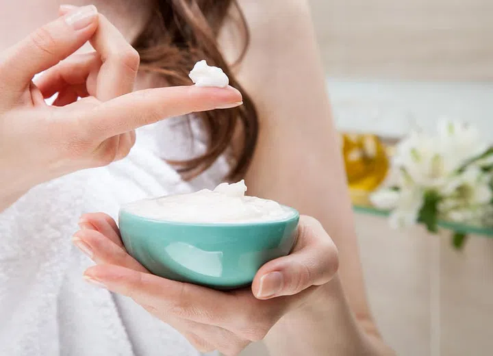 Closeup of woman hands holding a bowl with nourishing mask for applying to hair or skin; beauty and spa concept