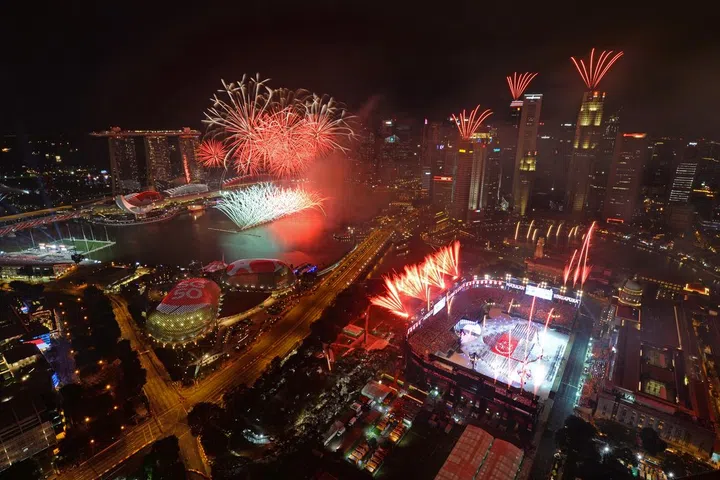 The fireworks display setting off at the Padang, from the rooftops of buildings and barges on water, at the National Day Parade (NDP) on 9 August 2015. The fireworks were the biggest and boldest to date, featuring a grand spectacle with pyrotechnics fired from two barges at Marina Bay and the rooftops of seven surrounding commercial buildings. The display included never-before-seen segments such as a rainbow arc and a shell display specially designed for the celebrations.