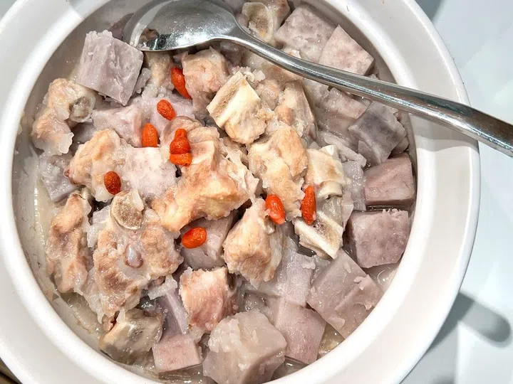 Overhead view of a casserole of Hunan delicacy.  Cooked cube yam with pork ribs garnish with goji  berries