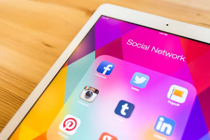 THAILAND - SEPTEMBER 07, 2014: All of popular social media icons on tablet device screen wood background.