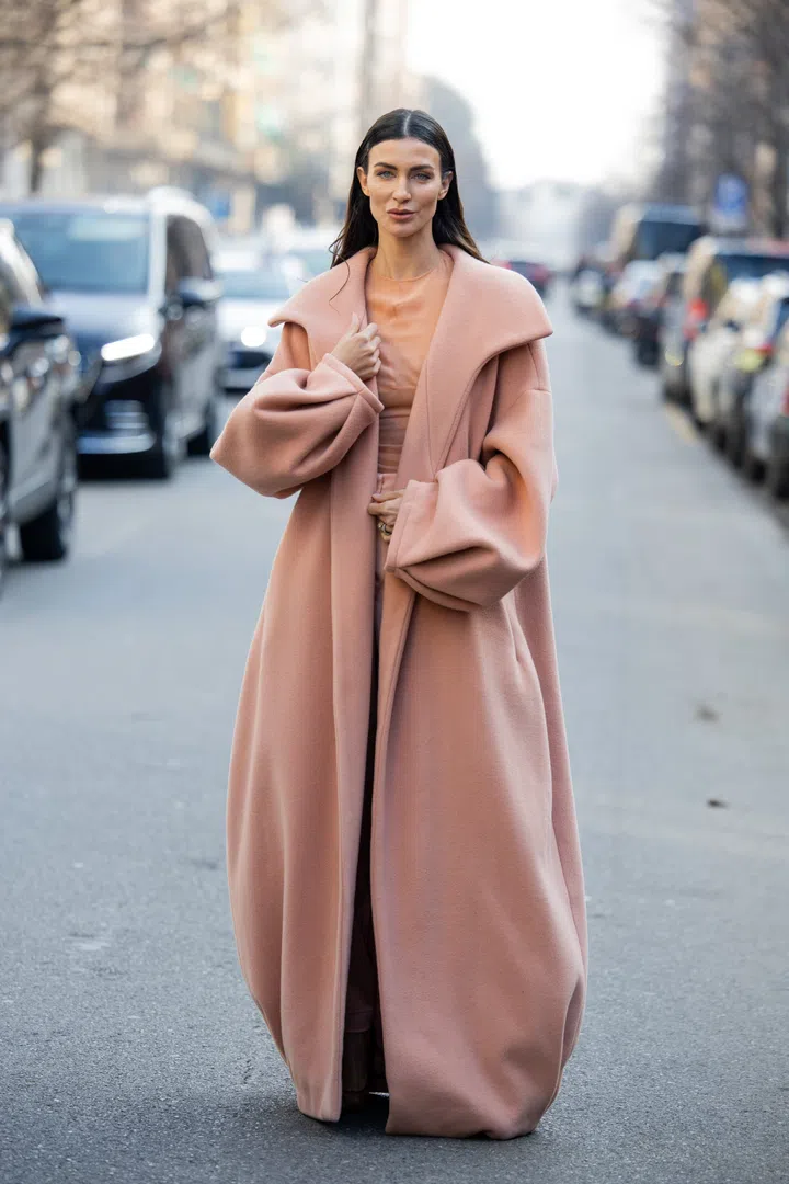 MILAN, ITALY - FEBRUARY 27: A guest wears salmon colored coat, pants, shirt outside Genny during the Milan Fashion Week Womenswear Fall/Winter 2025/2026 on February 27, 2025 in Milan, Italy. (Photo by Christian Vierig/Getty Images)