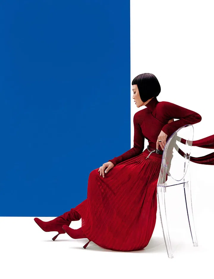 Ribbed turtleneck pullover with crossbody sash detail, pleated maxi skirt, and calfskin velvet boots, Hermes. Assorted rings, Cartier