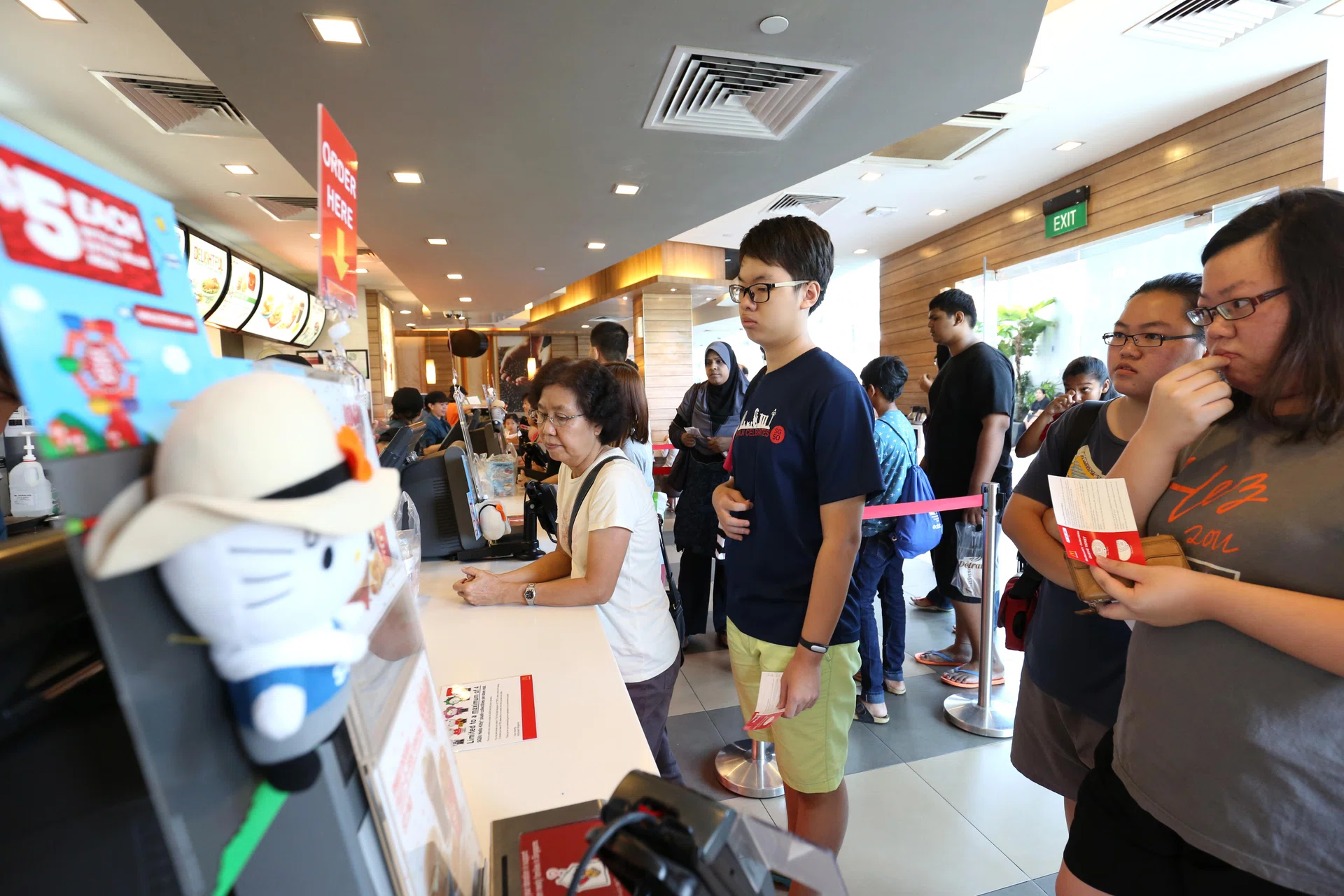 SINGAPORE - JULY 27:  Customers line up to buy the first SG50 "Trishaw Uncle" Hello Kitty plush toy as McDonald's SG50 Hello Kitty plush collectibles goes on sale at a McDonald's restaurant on July 27, 2015 in Singapore. The fast food chain is celebrating Singapore's Golden Jubilee SG50 by releasing six exclusive Hello Kitty soft toys, where each customer is allowed to purchase a maximum of four Hello Kitty soft toys per visit.  (Photo by Lionel Ng/Getty Images)