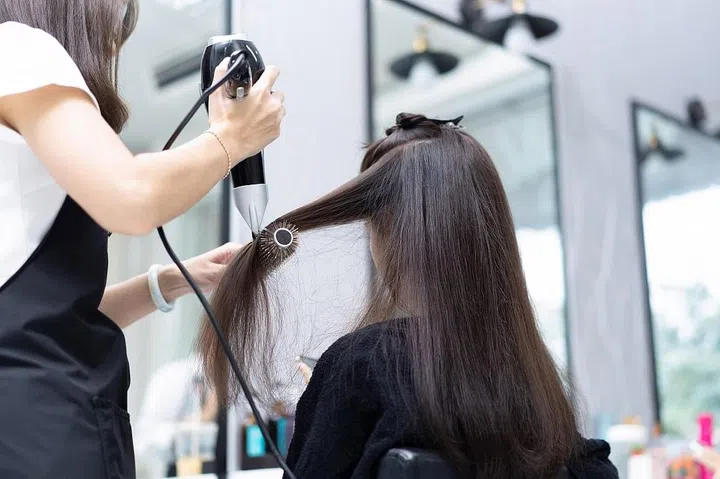Beautician doing hair for customers she is a beautiful woman
