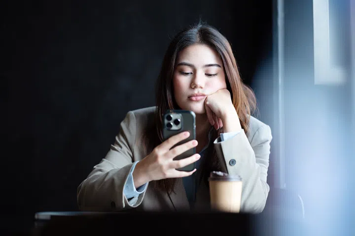Emotional Intelligence and Control Your Emotions As a Small Business Owner. A frustrated young businesswoman reading a problematic e-mail message over a smartphone during a business journey.
