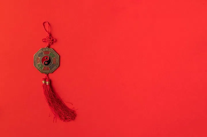 top view of festive oriental decoration with yin and yang sign, isolated on red