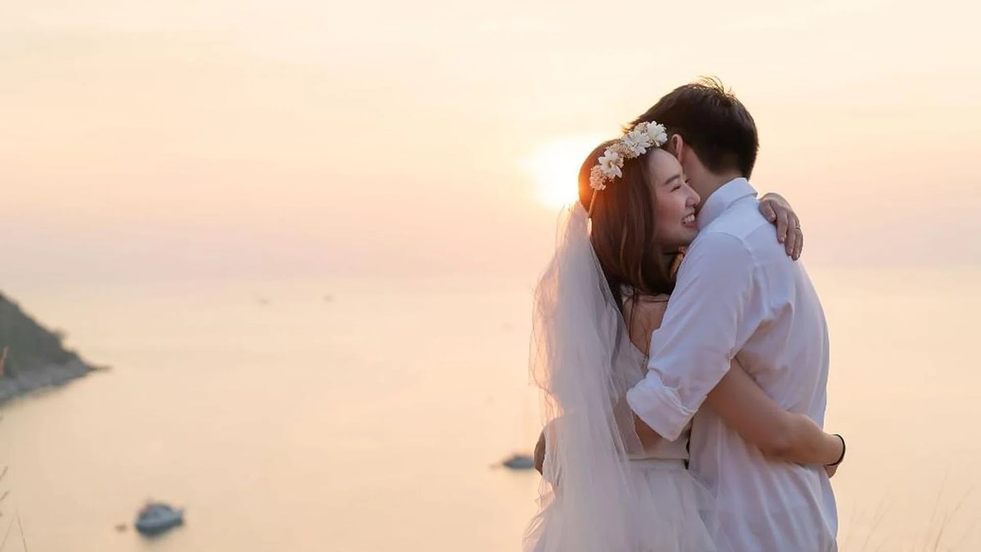 Happy young Asian couple in love having a good time with sea background