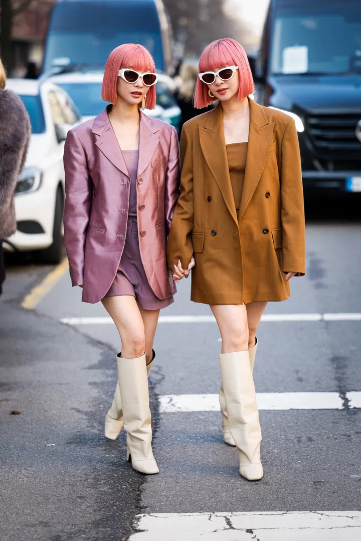 MILAN, ITALY - FEBRUARY 27: Ami and Aya Suzuki wears pink blazer, pink mini dress, cream boots, white sunglasses (L), beige blazer, beige mini dress, cream boots, white sunglasses (R), outside Max Mara, during the Milan Fashion Week Womenswear Fall/Winter 2025/2026 on February 27, 2025 in Milan, Italy. (Photo by Claudio Lavenia/Getty Images)