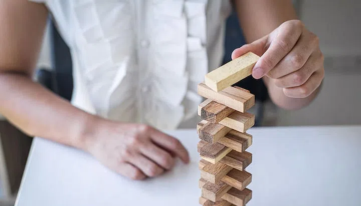 Alternative Risk and Strategy in Business, Hand of intelligent business woman gambling placing making wooden block hierarchy on the tower to planning and development to successful.