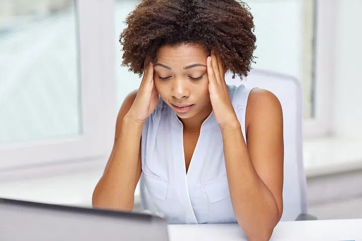 education, business, fail and technology concept - african american businesswoman or student with laptop computer and papers at office