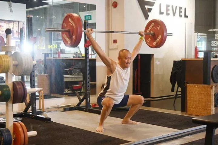 Mr Ng Siah Heng, 59, works out an hour every week with his personal trainer. He is doing a type of weightlifting called the snatch. ST PHOTO: DESMOND WEE