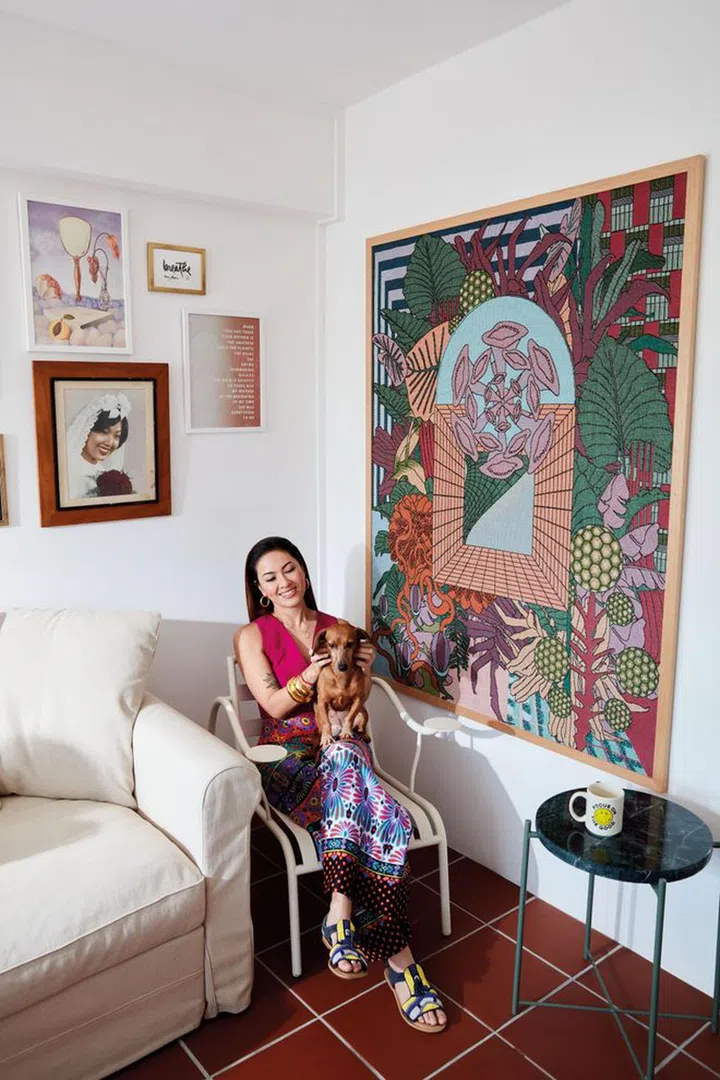 The guest bedroom doubles as a fitness and reading room. She wears her own top from COS, trousers from ALEX COLEMAN, sandals from ANTIK BATIK X MONOPRIX and cuff by MISHO DESIGNS. The centrepiece on the wall is a tapestry art by her friend, Singaporean artist Reza Hasni.Photo: Gan