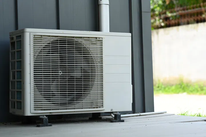 Air heat pump outside home or residential building. Air conditioner or heating ventilation air conditioning system.