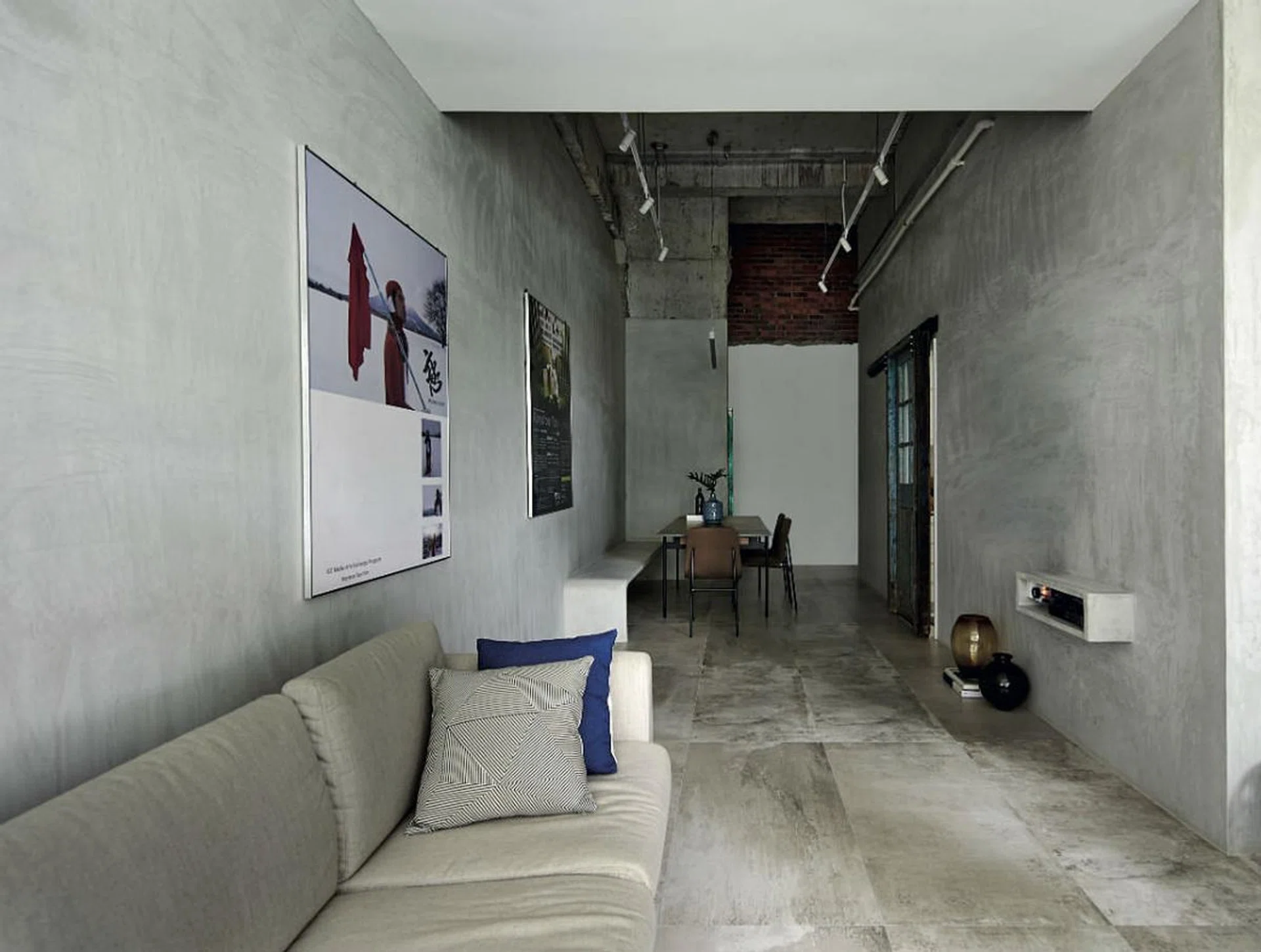 The loft-like home has a unique C-shape layout that hugs the kitchen. Raymond maximized the natural lighting in the living area by demolishing the wall of one bedroom, in favour of a larger living room with a full stretch of windows (not seen). Tableware and cushions, from Commune.