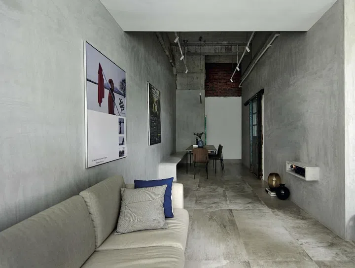 The loft-like home has a unique C-shape layout that hugs the kitchen. Raymond maximized the natural lighting in the living area by demolishing the wall of one bedroom, in favour of a larger living room with a full stretch of windows (not seen). Tableware and cushions, from Commune.