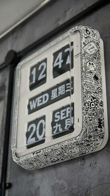 A graphic, retro wall clock with both Chinese and English in flight attendant Kenny Shoo’s 3-room HDB flat at Tampines Street 41.